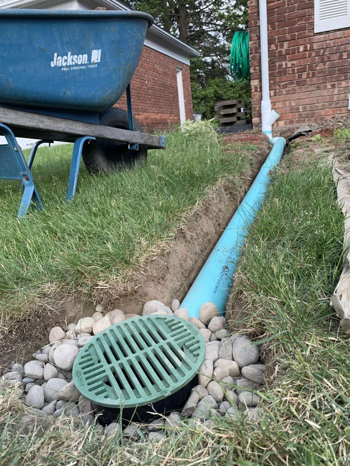 Installation of a residential yard septic system coming from a rain gutter attached to a home.