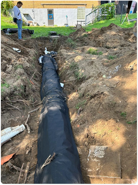 Installation of an underground septic system beside a commercial building.