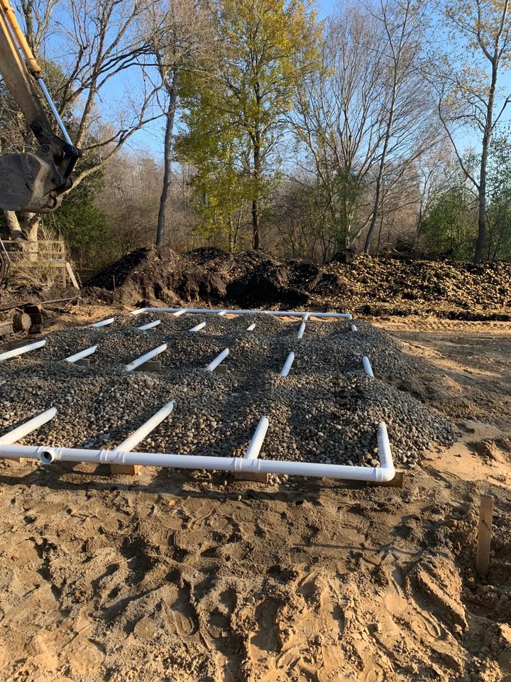 Installation and excavation of a large grid shaped septic system on a construction site.